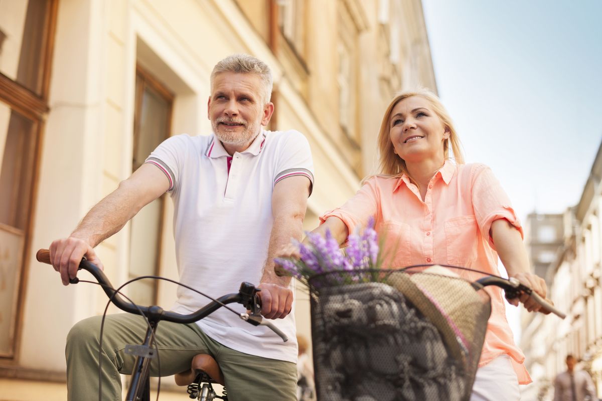 An elderly couple rides bikes together An elderly couple rides bikes together